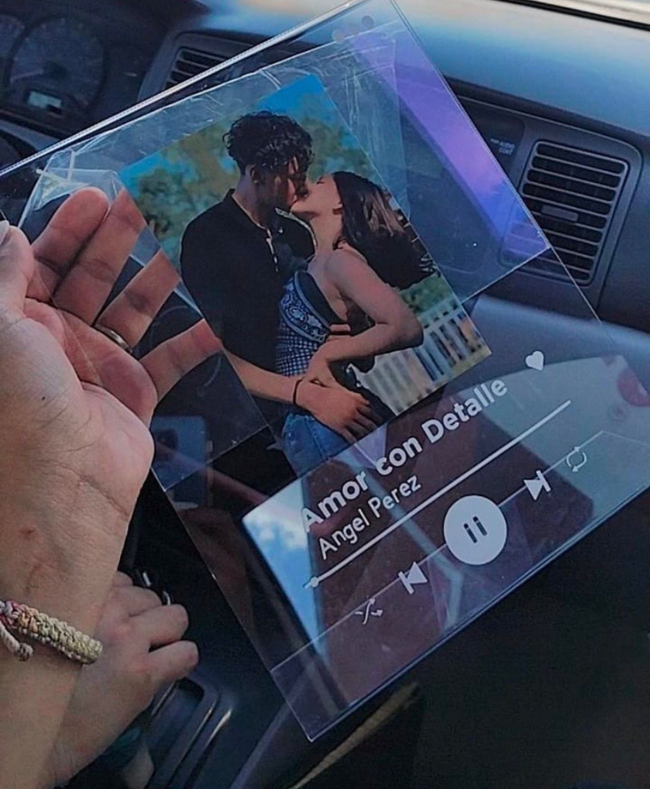 Cuadro acrílico personalizado sostenido en la mano, con foto de pareja y diseño de reproductor